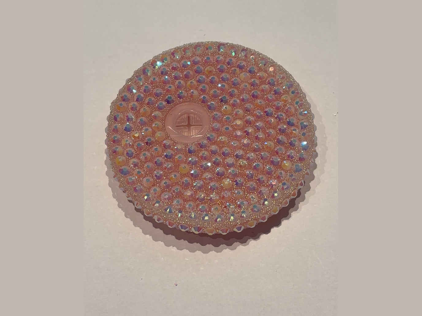 Peach colored 16oz lid covered in rainbow iridescent round beads with cross opening