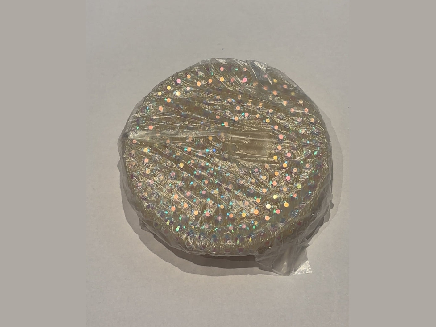 Gold tone 16oz lid with scattered iridescent dots and partial clear plastic wrap