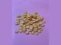Light yellow honeycomb shaped candy pieces on pink background