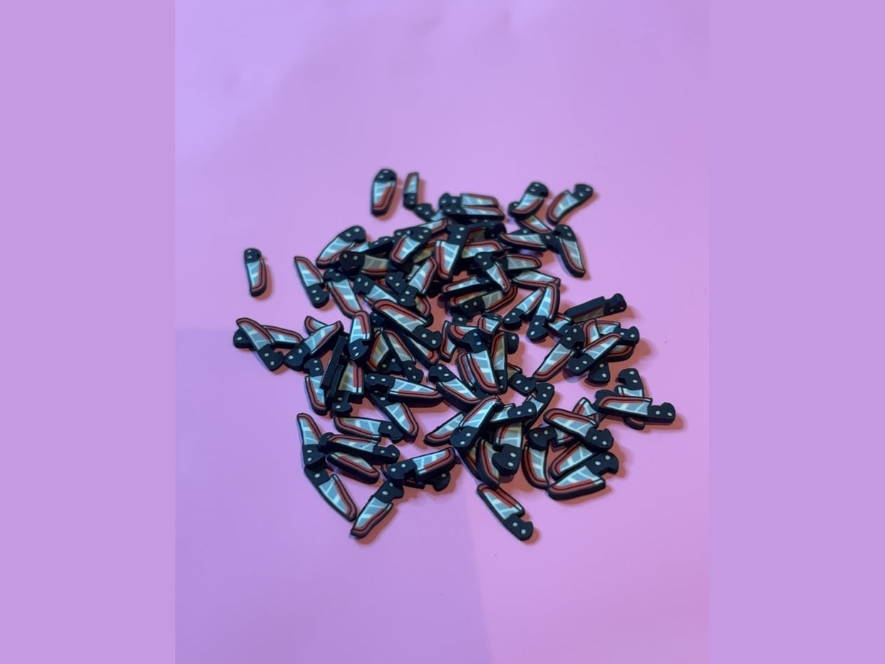 Black polymer clay knife charms with silver striped blades and white dot handles