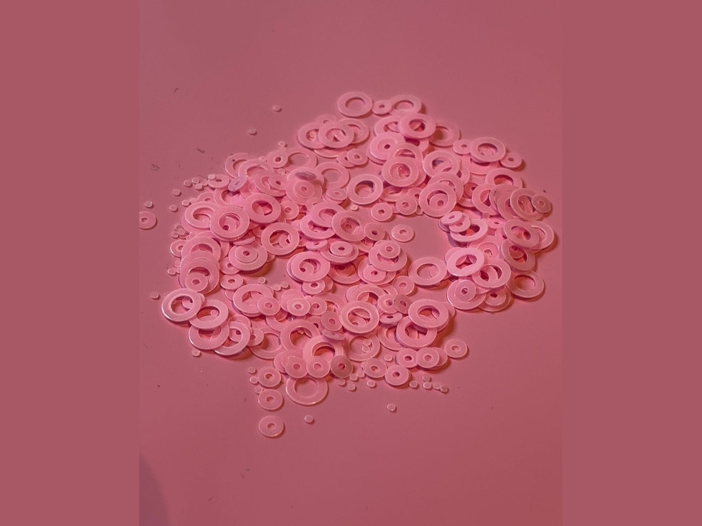 Pink translucent bubble shape craft pieces with central holes for glow in the dark projects