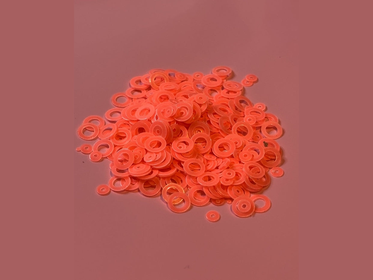 Orange glow in the dark bubble rings on pink surface