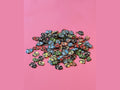 Colorful fish-shaped clay pieces with clownfish patterns on pink background