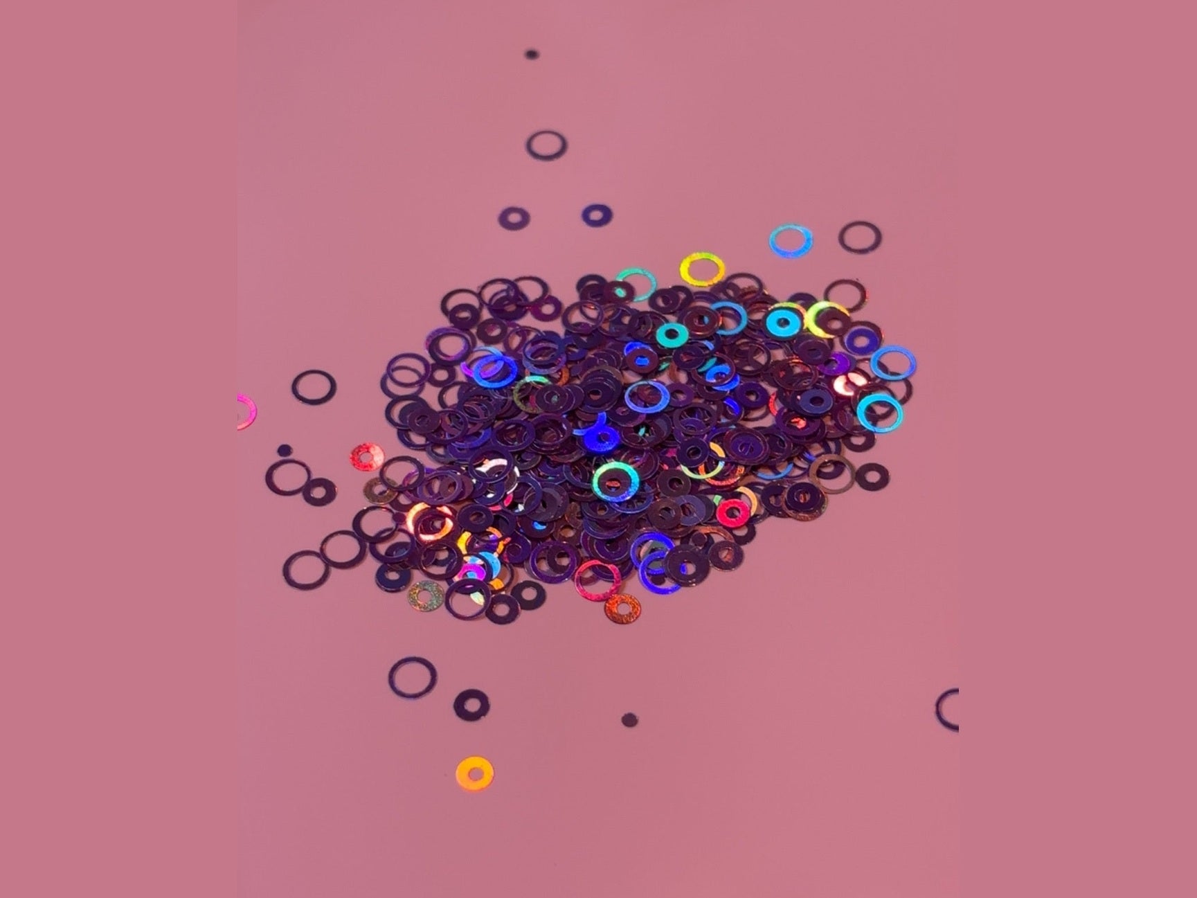 Purple Bubbles Glitter with iridescent sheen and colorful holographic rings on pink background
