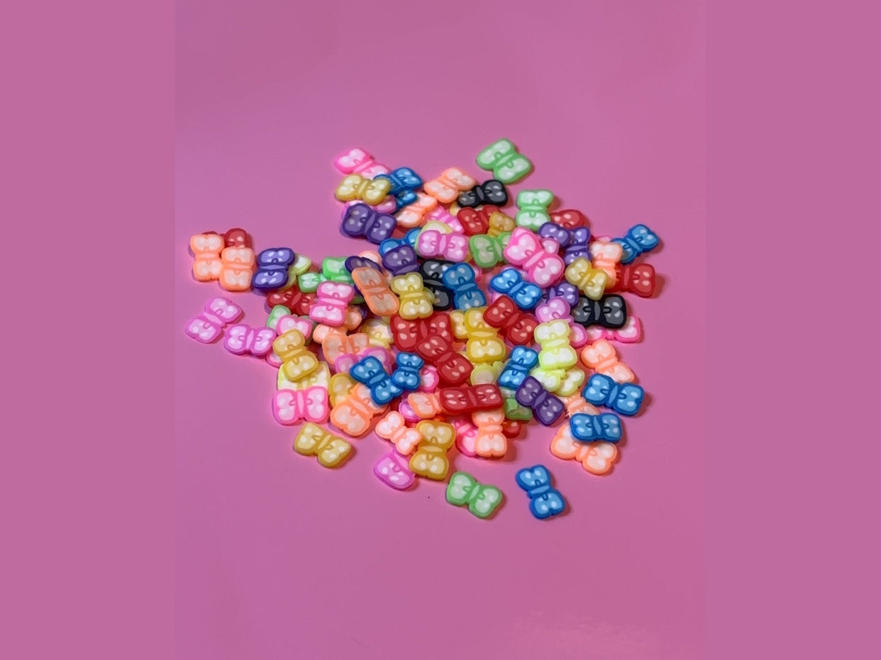 Colorful glossy plastic butterfly charms in assorted bright shades for crafts