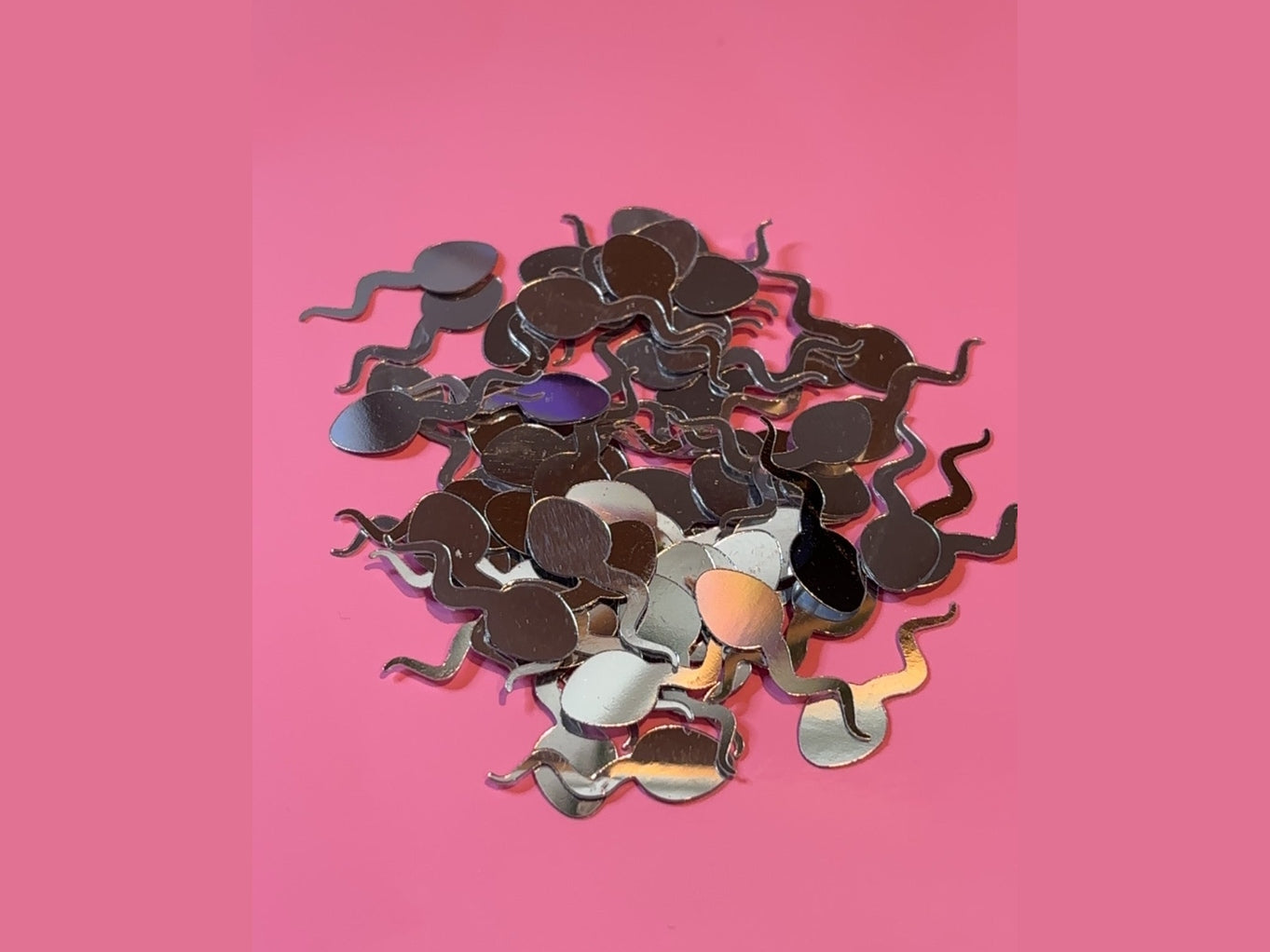 Silver holographic sperm-shaped swimmer cutouts with iridescent purple and gold highlights